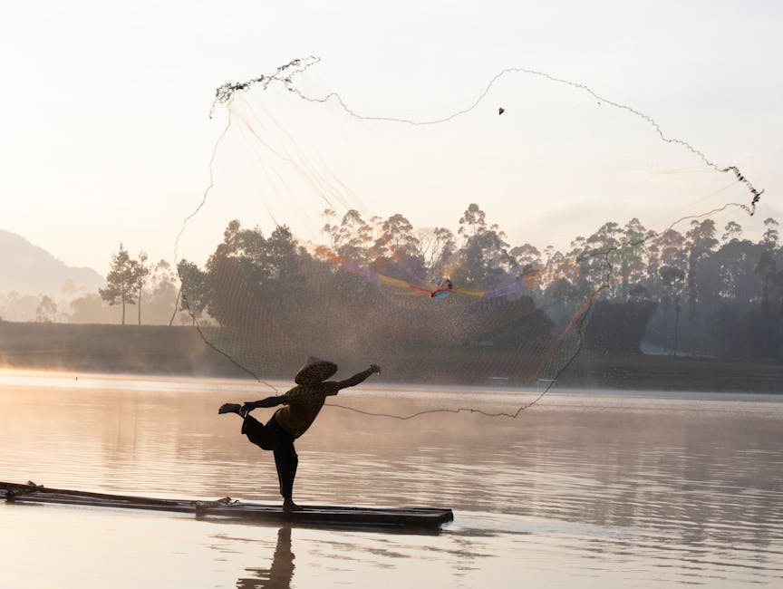 서부 자바의 고요한 칠레운차 호수에서 한 어부가 해돋이 무렵 능숙하게 그물을 던지고 있다.