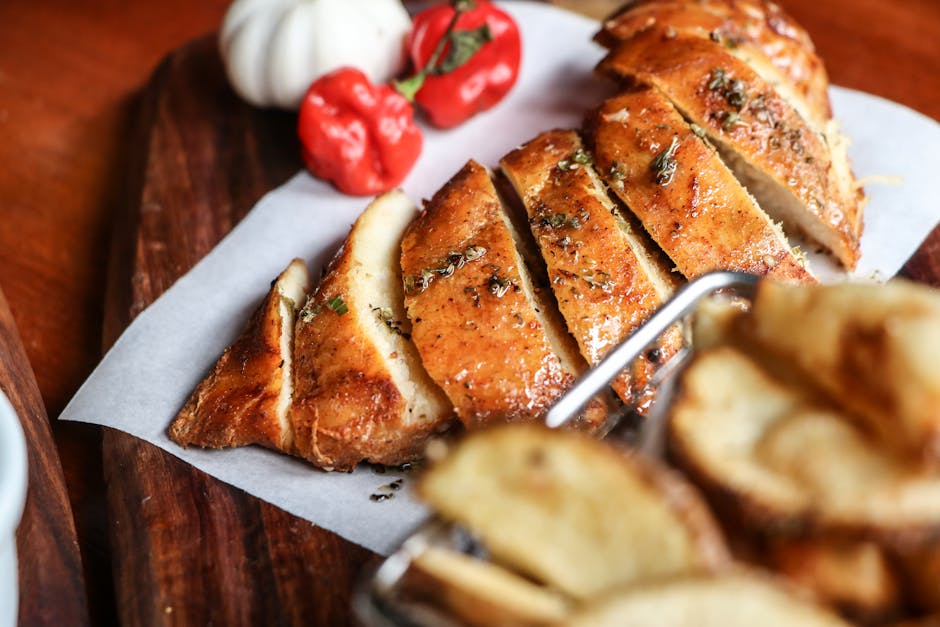 juicy sliced roasted chicken breast on wooden board