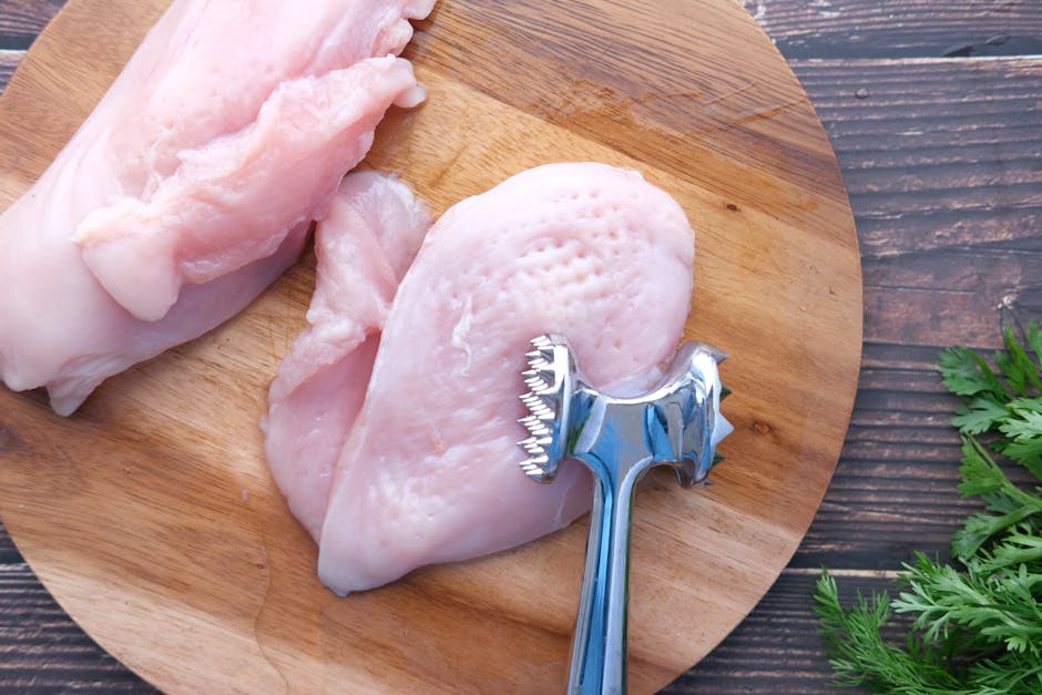 fresh raw chicken breast on wooden board with herbs