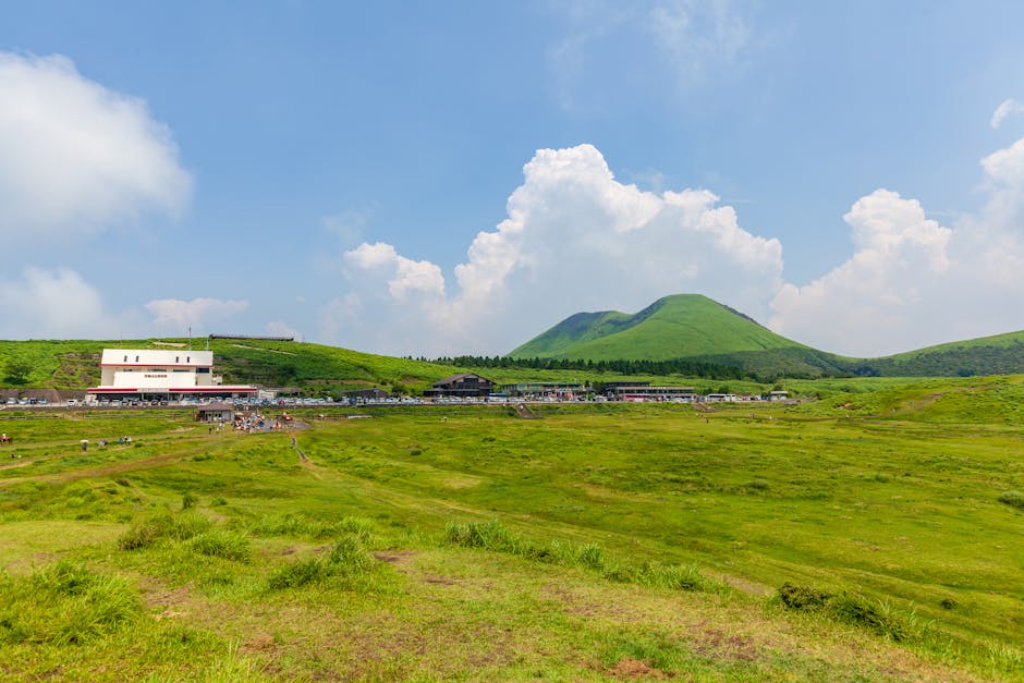 일본 규슈 아소의 화산 언덕과 푸른 하늘이 어우러진 생동감 넘치는 녹색 풍경입니다.
