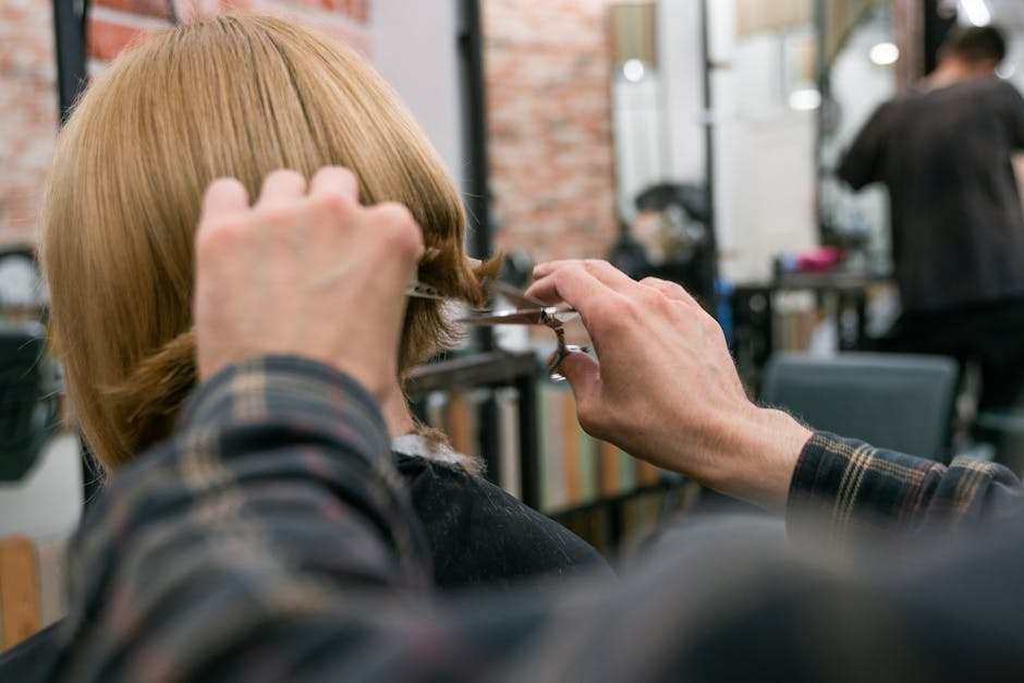 professional hair stylist cutting hair with scissors