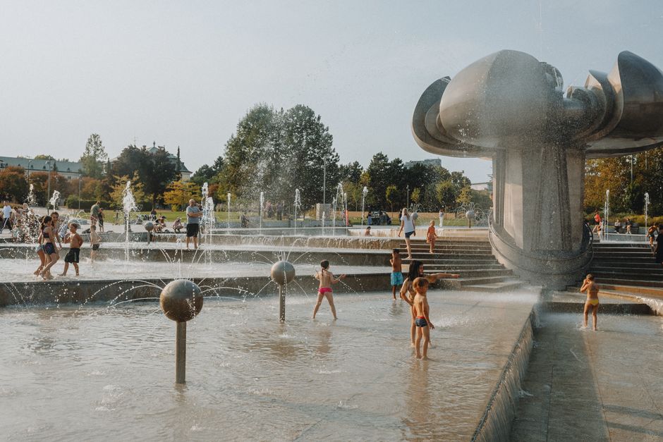 children playing in outdoor water park fountain