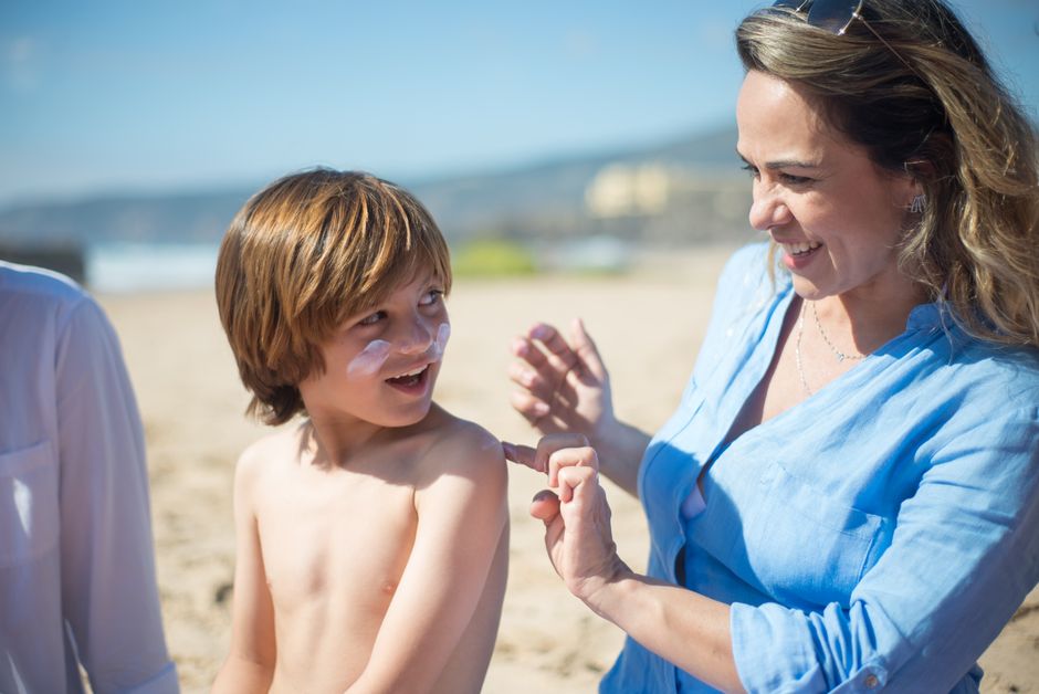 mother applying sunscreen to child face
